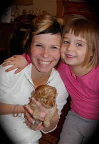 Labradoodle puppy with mum and daughter